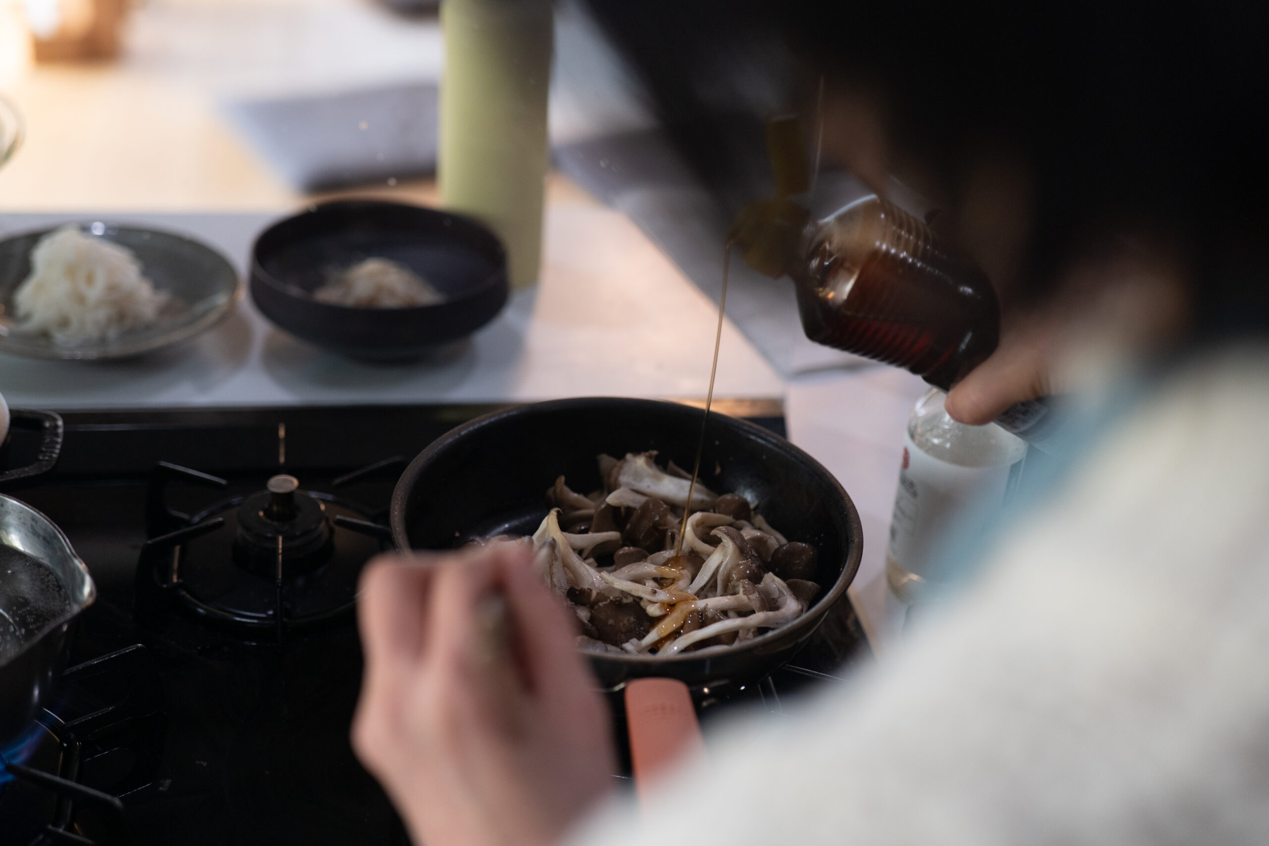 ごま油の香りが立つために仕上げに入れる様子